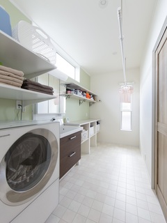 ２面に窓がある洗面脱衣室はサンルームと家事スペースも兼ねた広々とした空間。洗濯物を畳んだりアイロンがけをしたり、作業デスクは使いやすい高さに設定。