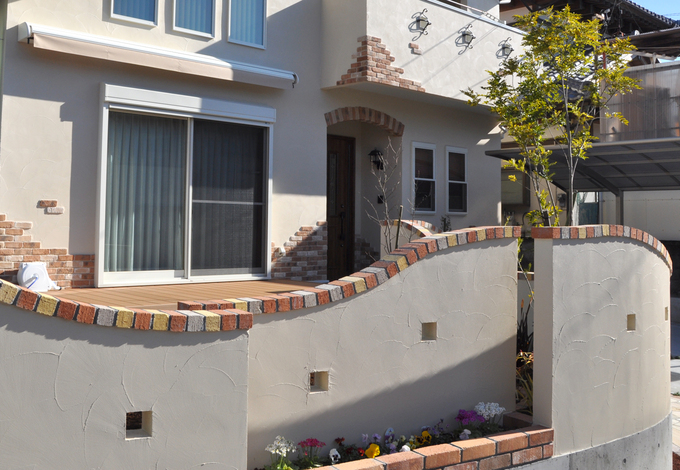 建物とお揃いの可愛らしいレンガ調の壁は足元がミニ花壇になっている