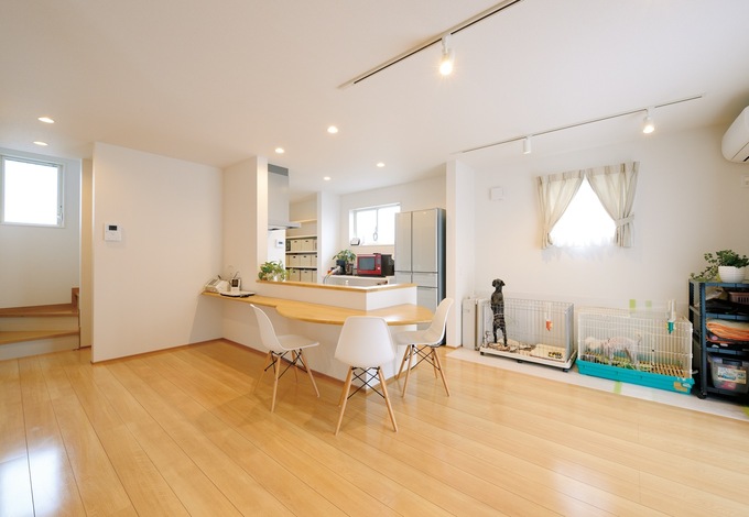 アーモンド型のカウンターテーブルを中心に、明るくのびやかな空間が広が る。テーブルを置かずに済むので、愛犬たちのケージを並べて置ける。家族も愛犬もいつも一緒の仲睦まじいFさんご一家