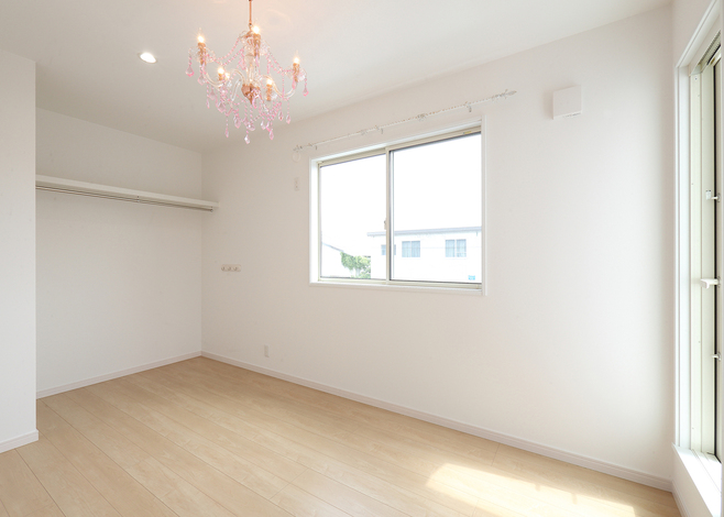 洋室はクローゼットの扉をなくすことで空間を広く感じる。シャンデリアが部屋を照らす