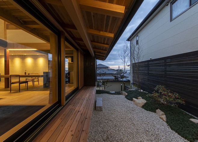 窓を大きく開け、広い庭をとって十分な採光を確保。しっとりとした風情ある庭に、七輪を出してサンマを焼いたり、BBQを楽しんだり、縁側のような長いウッドデッキが家族のとっておきの場所になっている