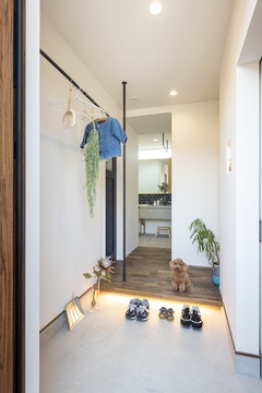 遊んで帰ってきたお子様が、直接洗面に向かうことができる玄関。お客様のコート掛けと手摺を兼ねたアイアンと照明がアクセント。