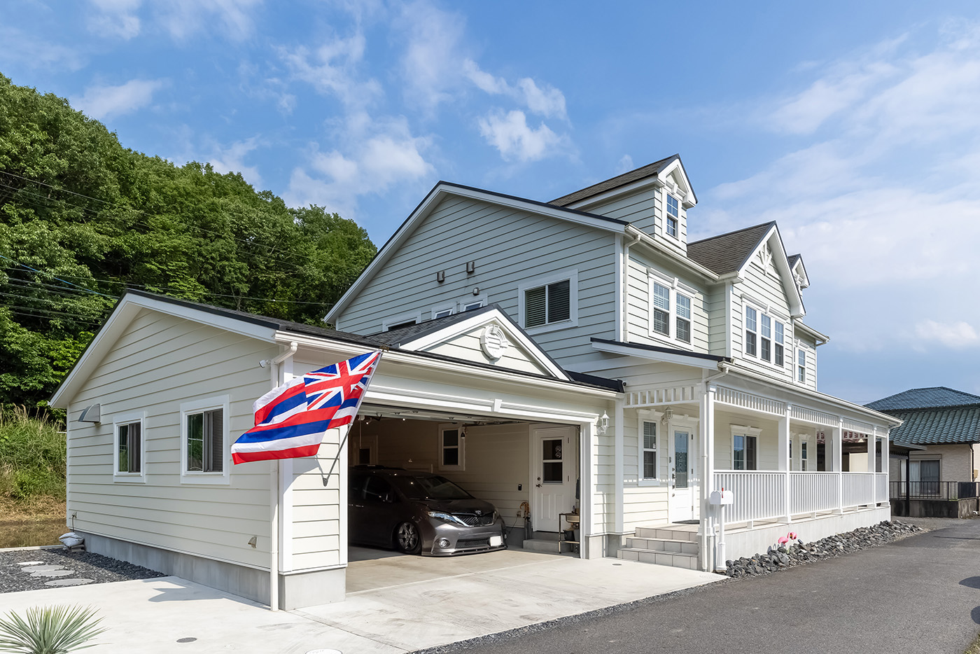 ジェネラルアメリカンホーム【輸入住宅、間取り、ガレージ】ハワイのホテルの色合いを取り入れ、ガレージのある1階の外壁はアイボリー、2階部分はグレーにしたI邸