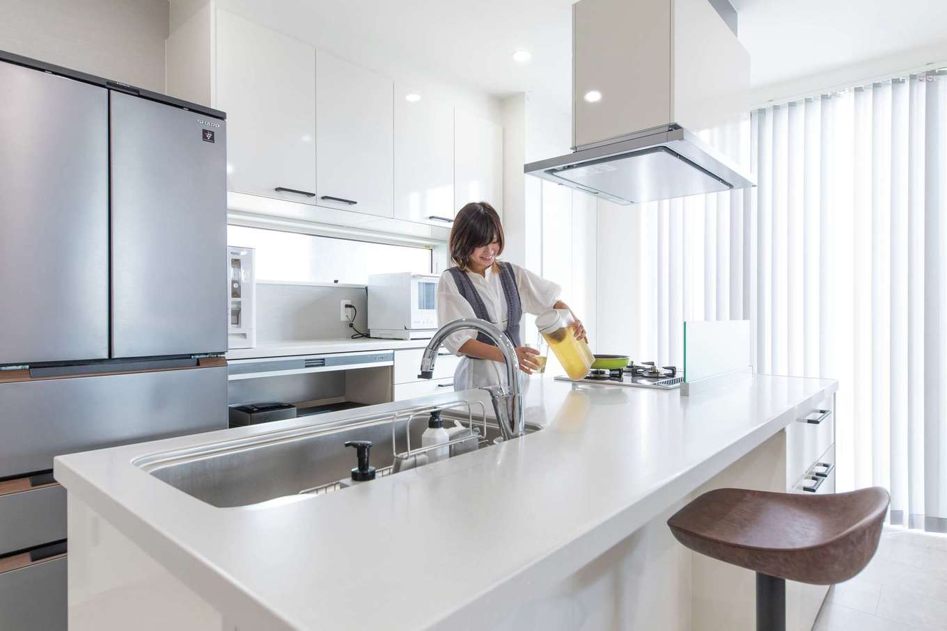 アフターホーム【1000万円台、デザイン住宅、間取り】料理をしながらTVを見たり、子どもを見守ったり。左右どちらからもリビング・ダイニングに移動できるアイランドキッチンは奥さまのお気に入り。冷蔵庫に近くサッと飲食できるカウンターはご主人の好きな居場所だ
