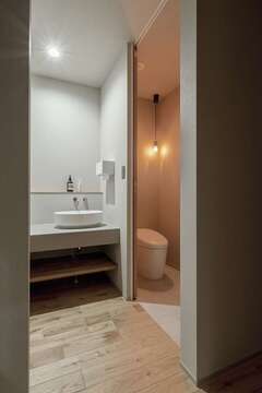 1階の洗面とトイレは生徒さんの使用も想定。クロスのトーン、水洗のセレクトなどにより、スタイリッシュに仕上げられた