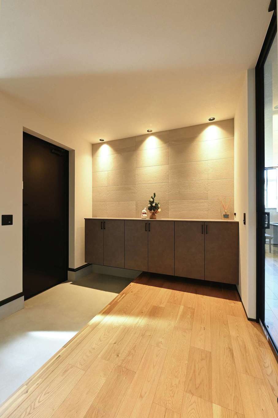 REIWA HOUSE（令和ハウス）【省エネ、間取り、平屋】ゆったりとした広さを確保した玄関ホール。シューズボックスの上に調湿・消臭効果の高いエコカラットを貼り、間接照明を当ててニュアンスを出した