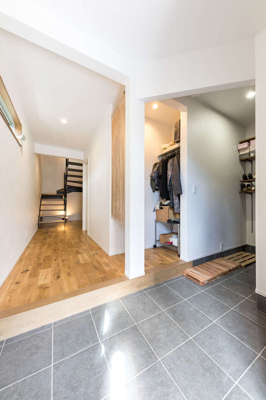 建築システム（狭小住宅専門店）【狭小住宅、間取り、屋上バルコニー】家族と来客の動線を分けた玄関。シューズクロークから上がるとコート掛けや荷物置きの棚があり、出がけや帰宅時に便利