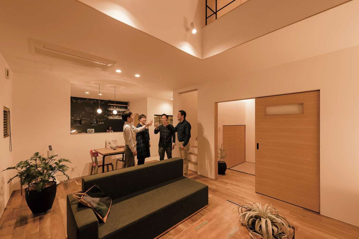 Hands Works（アオイ建築）【デザイン住宅、夫婦で暮らす、間取り】家中をひとめぐりしたところで、リビングで乾杯。落ち着いた深みのあるアカシアの無垢床と珪藻土の自然素材が心地いい。エアコンは天井のビルトインにしてすっきり