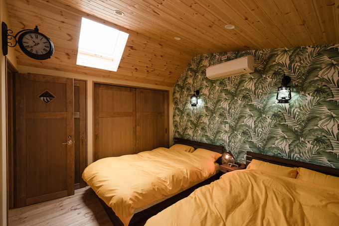 天窓付きの寝室。トーンを抑えた黄と緑で安らぎのひとときを演出する