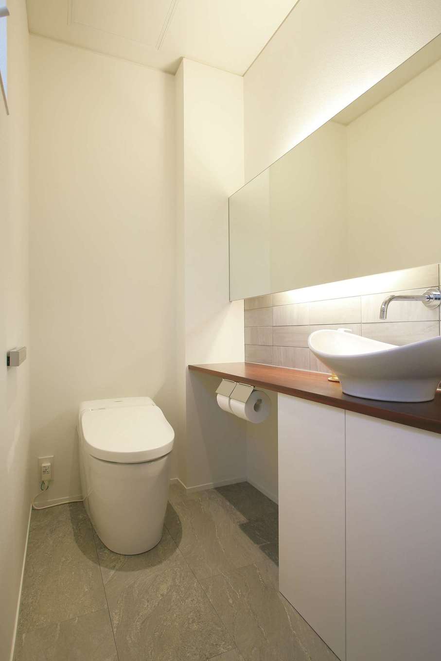 神谷綜合建設 カミヤの家【デザイン住宅、収納力、二世帯住宅】1階のトイレ。間接照明やタイル、木の組み合わせで、トイレでありながら生活感を感じない空間に