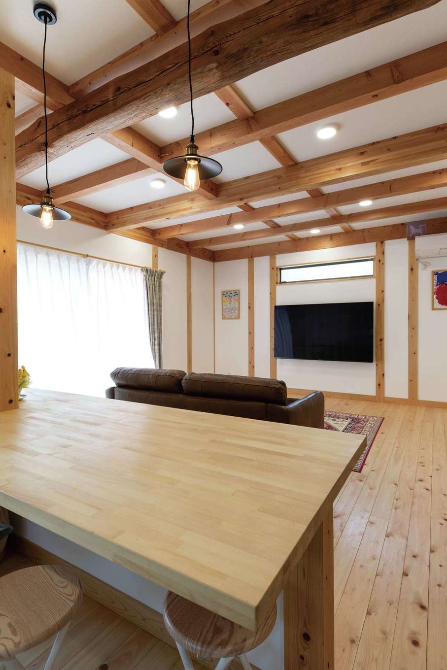 ぽっくハウス静岡（東海ハウス）｜天井の木組みがシンプルなLDKに豊かな表情を添える。テレビはコードが見えないように隣接する部屋に置いた機器につなぎ、テレビ台もなくしてすっきり