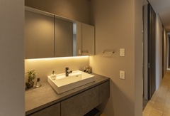 洗面台は脱衣室とは別にし、オープンスペースにレイアウト。三面鏡の中に細かなものを収納して、生活感が出ないようにしている