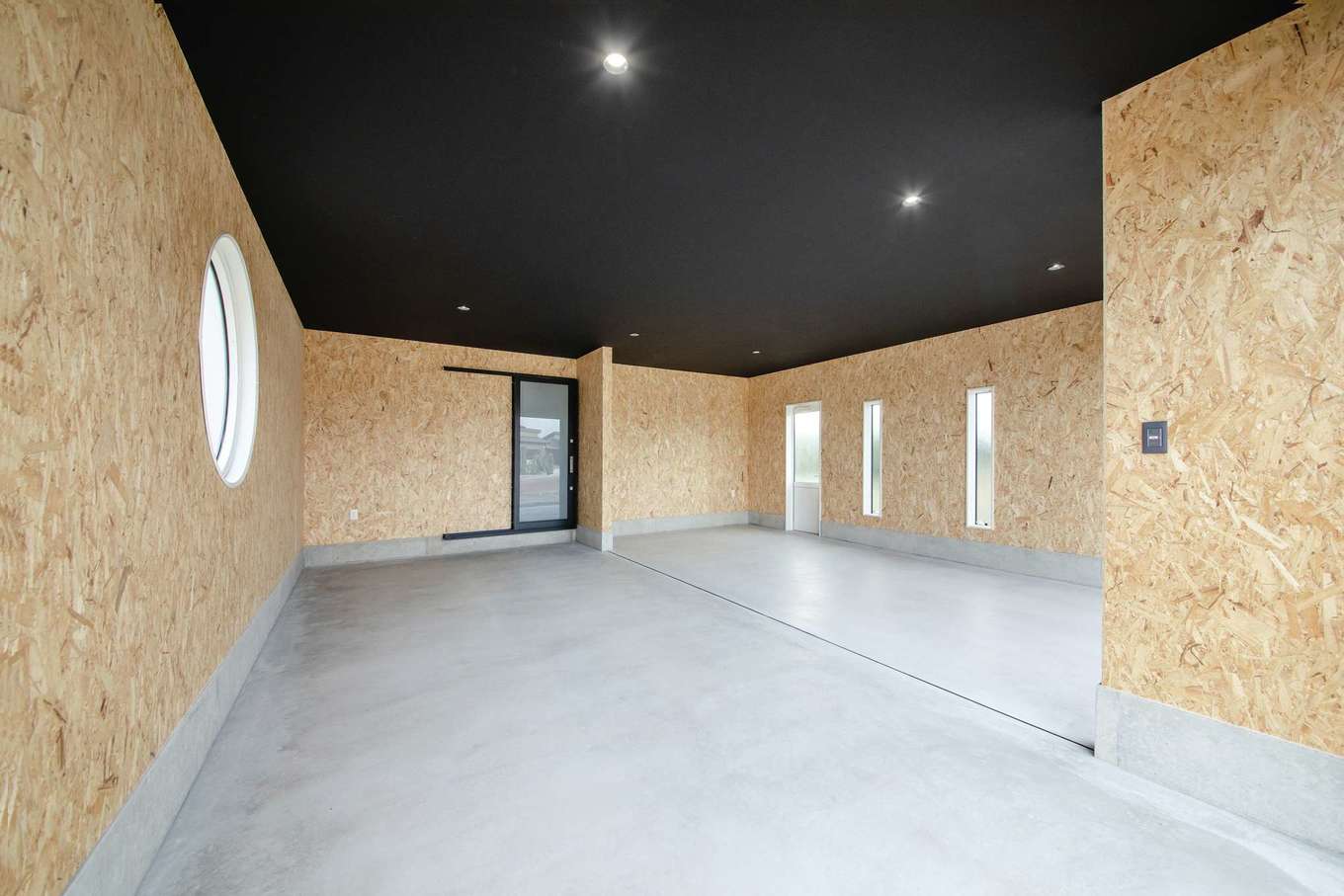 未来創建【デザイン住宅、省エネ、平屋】愛車をメンテナンスするために設けた器具庫。居室につながる出入口をつくることで、雨の日も濡れずに移動できる。