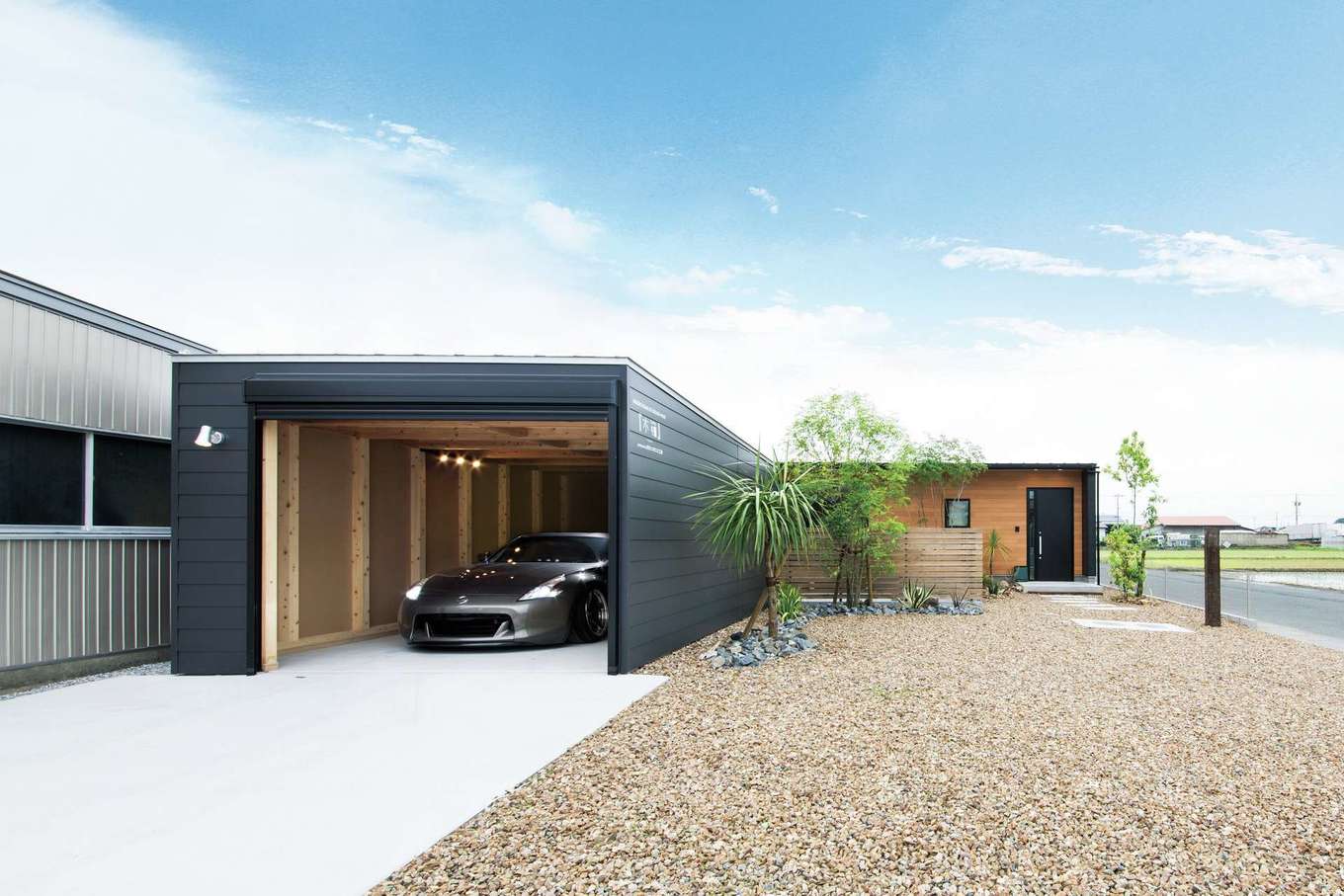 住たくeco工房【1000万円台、平屋、ガレージ】「木箱ハウス」の平屋プランと「木箱ガレージ」をL字型に配置したレイアウト。統一感があり、いっそうスタイリッシュに。庭のグリーンもアクセントになっている