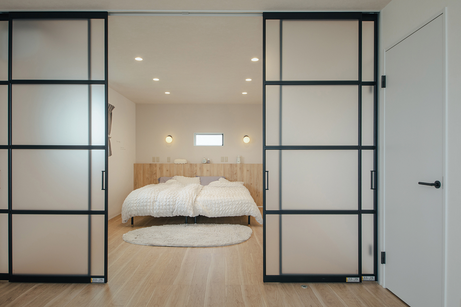 will建築工房【デザイン住宅、間取り、インテリア】3階の主寝室。海外のリゾートホテル風に、ガラス張りの格子ドアで空間を仕切れるようにした