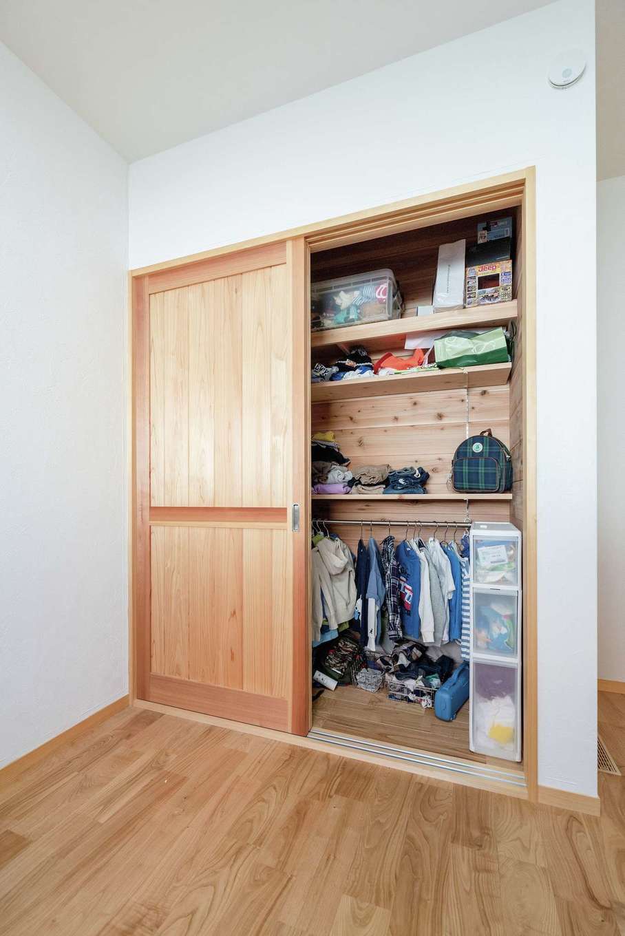 藤田工務店【和風、自然素材、平屋】5畳の子ども部屋。収納の内部にも無垢の木や漆喰を使用。湿気がこもりにくく、大切な衣類や荷物をカビから守る。子ども部屋のクローゼットはハンガーパイプも含めて棚全体を可動式に。成長に合わせて調整できる