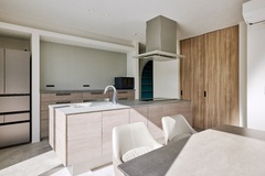 淡いグリーンのアクセントクロスと木目が調和したキッチン。落ち着いた色合いが温かみを感じさせ、心地よい空間を作り上げている。