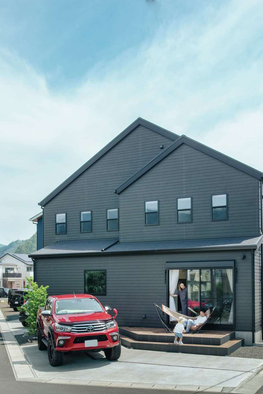 ハートホーム【デザイン住宅、趣味、スキップフロア】三角屋根とラップサイディングの黒い外壁により、個性とモダンさが調和した。耐久性に優れるタイルデッキはリラックスタイムに活躍