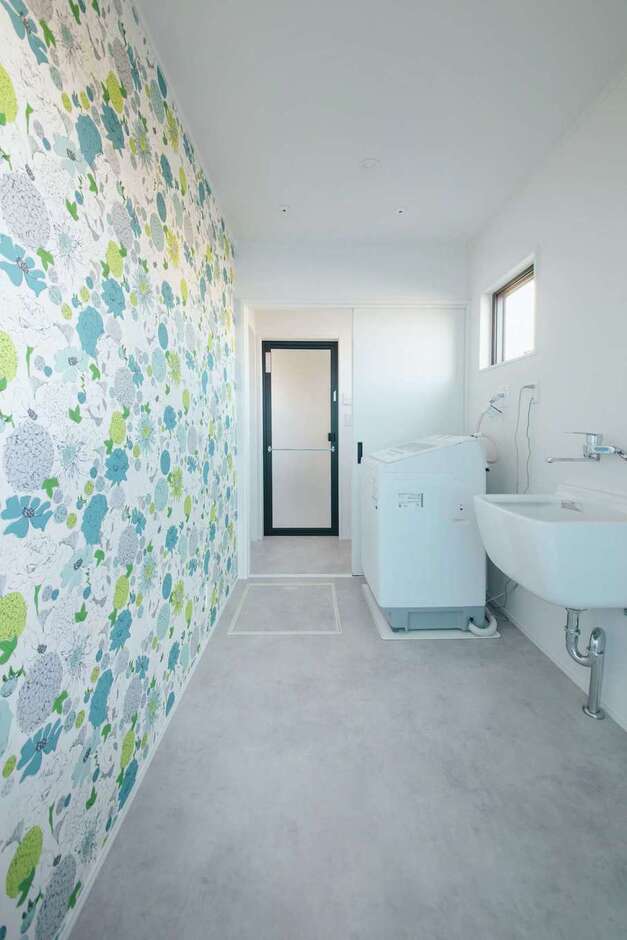 ランドリールームは奥さまセレクトのクロスで、明るい気分に。ご主人の作業着や上履きを洗えるようスロップシンクを設置