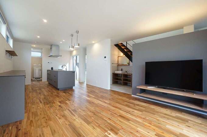 18畳のLDK。表情豊かなマーブル模様の床は無垢のアカシアで、経年変化も楽しみ。テレビステーションの上部を空けてあるので、玄関ホールの気配が伝わってくる