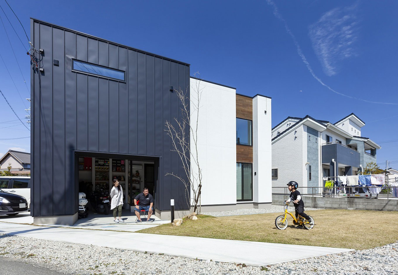 S.CONNECT（エスコネクト）【収納力、趣味、建築家】紺と白の建物が2棟隣接しているかのように、趣向の異なる2つのデザインのコンビネーションが絶妙な外観。バイクのインナーガレージも間口を広くとってあり、開放的な印象