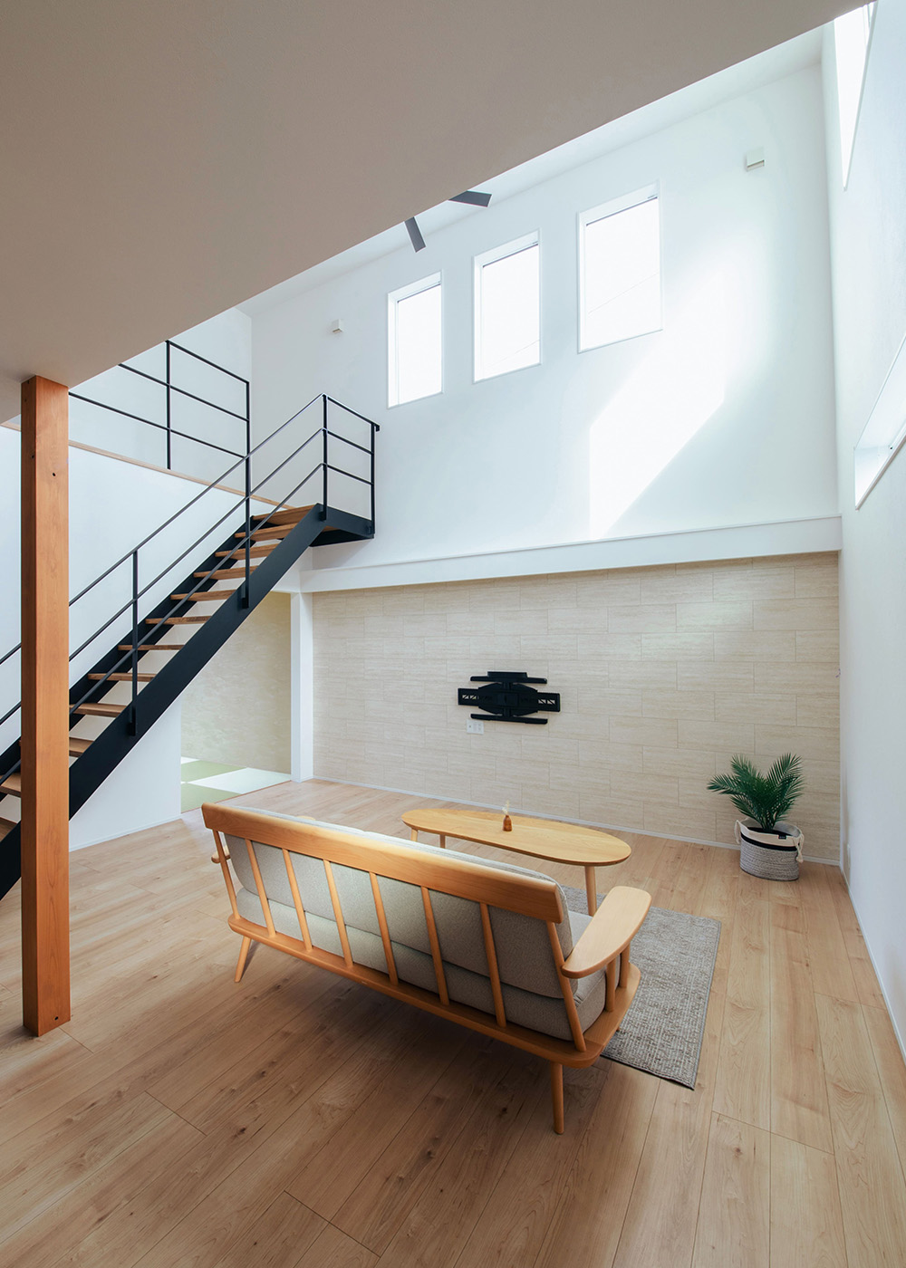 DAITOKU（大得工務店）【デザイン住宅、省エネ、間取り】南側に隣家が迫っているため、吹抜けの高窓から光を取り込み、明るさとプライバシーを両立。ソファに座って見上げると窓越しに青空と流れゆく白い雲が見えて、くつろぎの時間を楽しめる