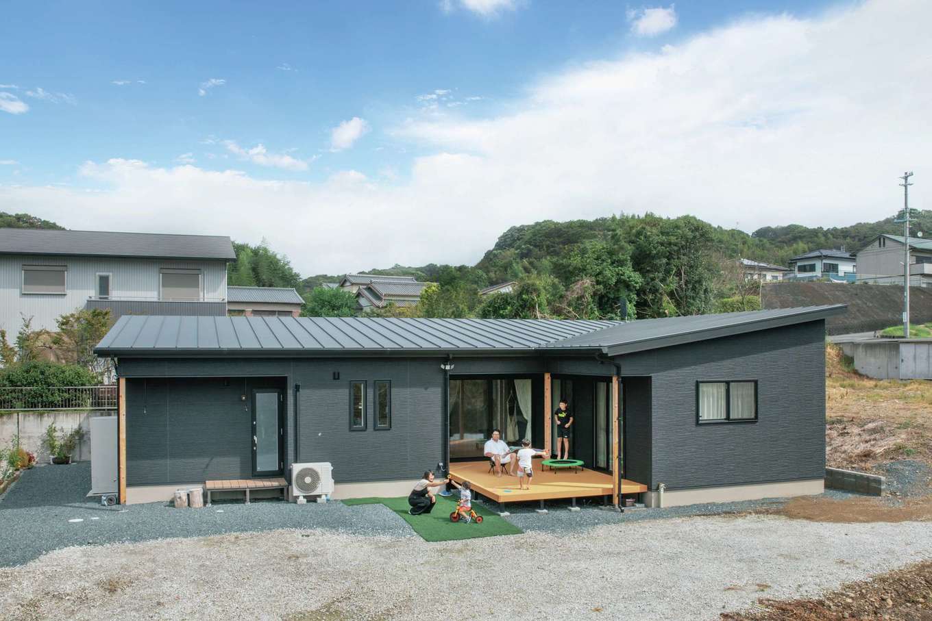子育て安心住宅 Design Craft Office【デザイン住宅、子育て、平屋】ウッドデッキを囲むように凹凸を付けた外観。黒い外壁はご主人がセレクト。ウッドデッキはダイニングとリビング、子ども部屋の前の廊下の三方向から出入りできるようになっているため、通路としても利用することが多いそう