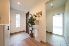 明るい自然光が差し込む玄関ホールと土間収納。土間収納からインナーガレージへの接続もあります。玄関を上がったところにあるお洒落な手洗いコーナーが便利です。