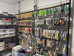 釣り具や道具を整理整頓できる収納スペース。壁面を最大限に活用し、ディスプレイのように美しく陳列された収納が印象的。多くの小物を効率的に管理可能。