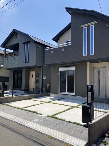 モダンなデザインの二棟の外観。落ち着いた色合いの壁とシンプルなラインで、街並みに調和しながらも個性を放つスタイル。