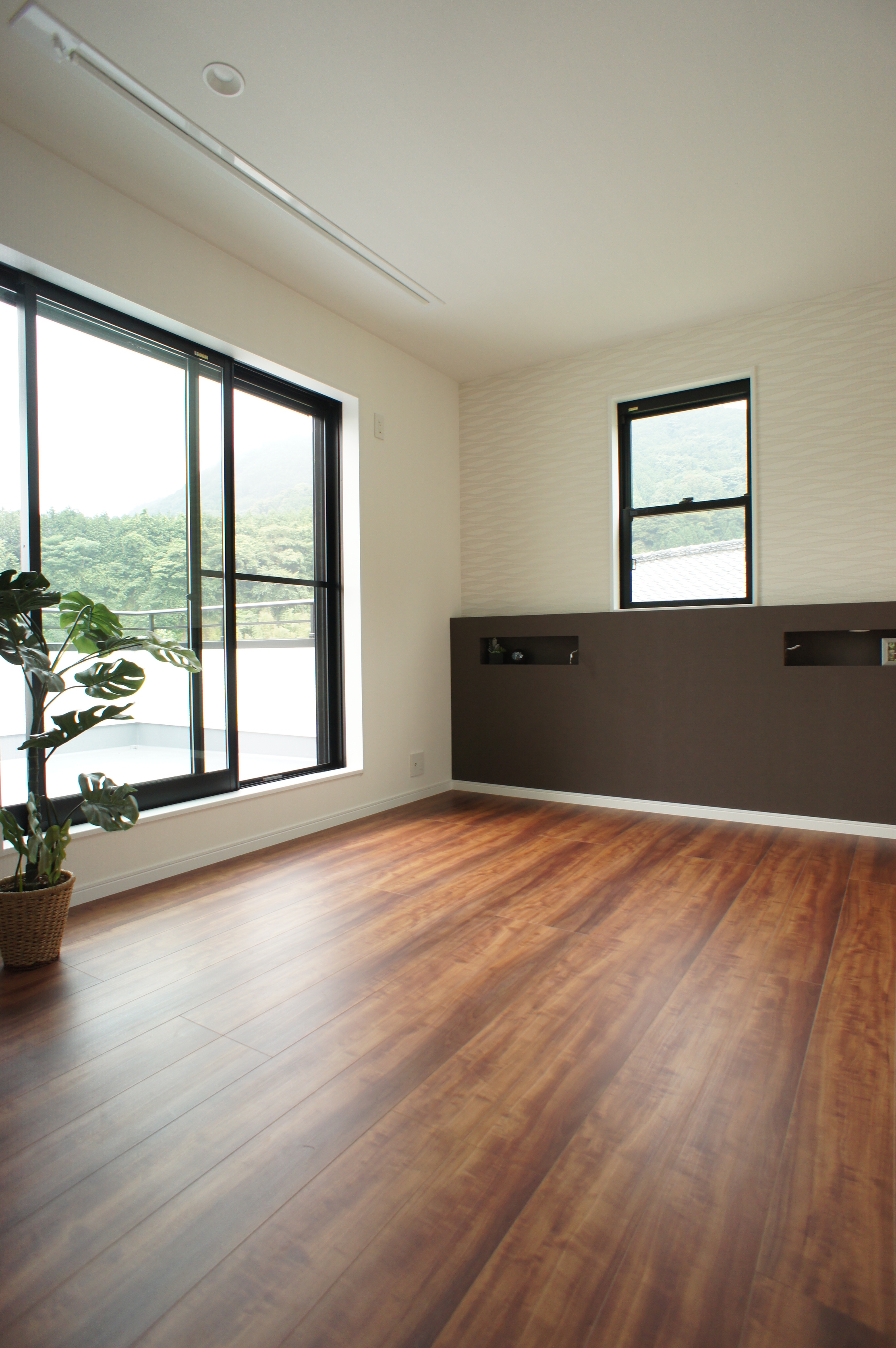 小野田産業～designers house project～｜明るい自然光が差し込むシンプルな居室。豊かなフローリングの色合いが暖かみを添える。
