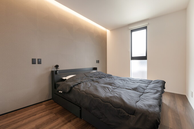 落ち着いた雰囲気の寝室。シンプルなデザインで、心地よい眠りを誘う空間を作り出す。高級感ある仕上がりが特徴的である。