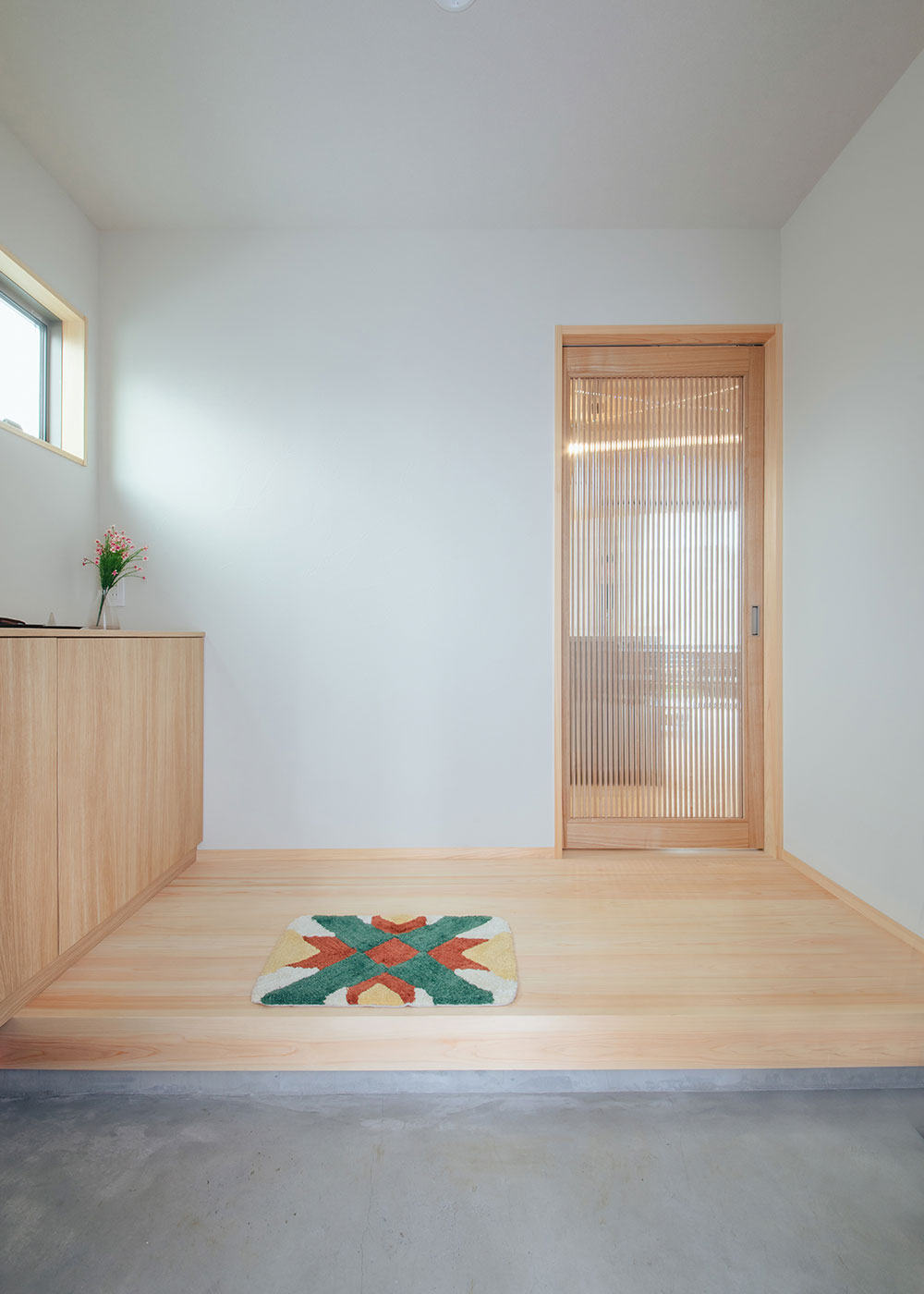 フジモクの家（富士木材）【子育て、自然素材、平屋】富士ヒノキの香りと清々しさに満ちた玄関。土間部分はモルタル仕立てに。光と気配を適度に伝える建具は、同社による造作