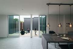 グレージュを基調としたホテルライクなインテリアにコーディネートした20畳のLDK。廊下や窓を減らして断熱・気密性能を高め、広い中庭から十分な光と風を招き入れる。外と中のつながりを感じながら暮らせる空間が心地いい