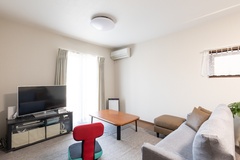 自然採光が入り込み明るい空間。シンプルで落ち着いた雰囲気のリビングルーム。