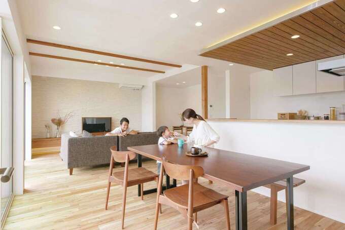 アカシアの無垢の床が広がるＬＤＫ。開口部を広くして、外にはウッドデッキを設け、庭との一体感を楽しめる。キッチンからはリビングや小上がり、庭まで見渡せる