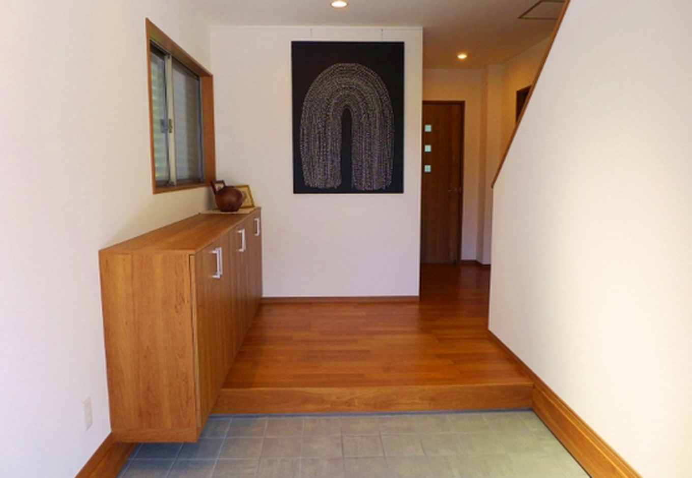 建築システム（狭小住宅専門店）【収納力、夫婦で暮らす、ガレージ】幅がゆったり広めの玄関スペース。高さを落としたカウンタータイプの靴箱を設置して圧迫感のない空間に