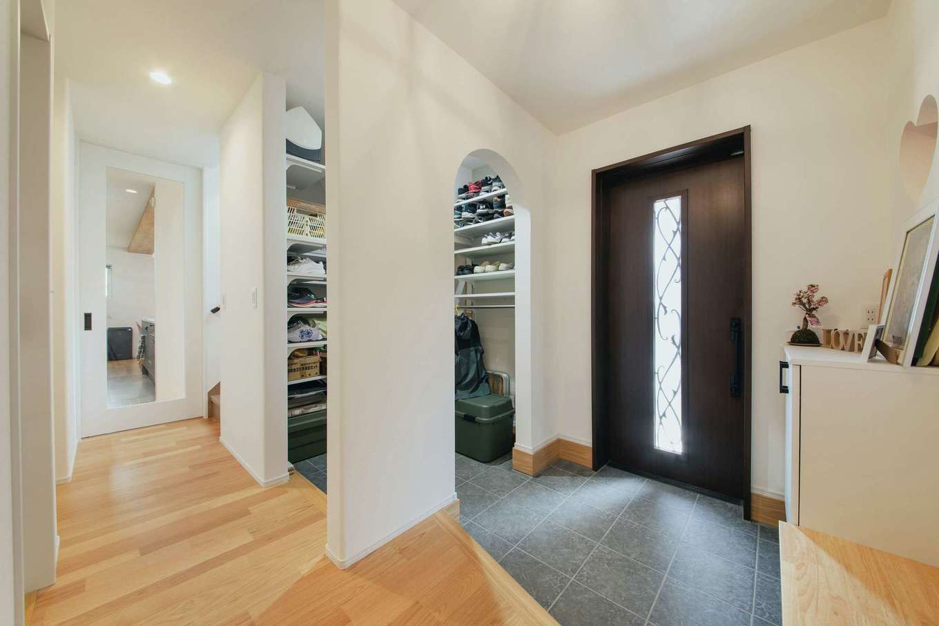 子育て安心住宅 Design Craft Office【デザイン住宅、収納力、間取り】シューズクローク付きの広々とした玄関。クロークへの入り口はR型にしてかわいらしく演出