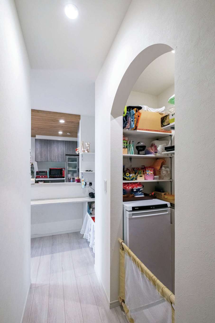 工藤建設【デザイン住宅、子育て、間取り】キッチンの隣にはパントリーを設置。扉はつけず、Rの垂れ壁でかわいらしく