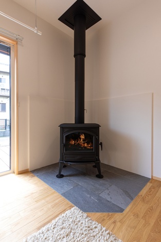 薪ストーブが印象的なリビング。家族や友人と共にゆったりと過ごせる空間である。