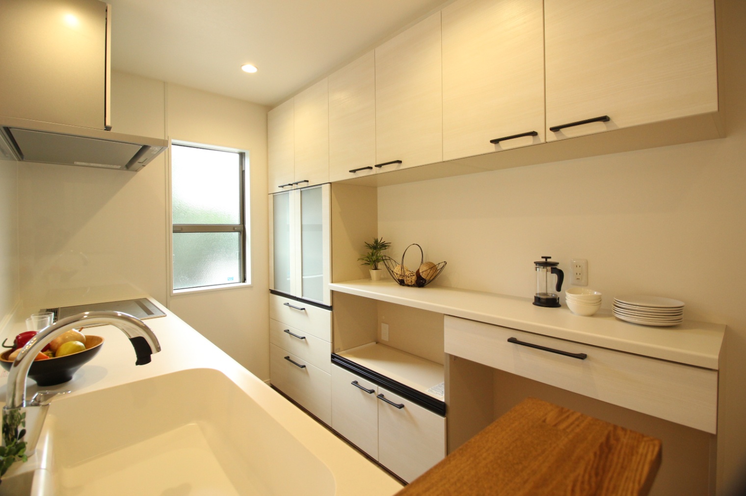 小野田産業～designers house project～｜明るく機能的なキッチン。収納スペースが充実しており、調理を効率的に行える設計である。シンプルながらもスタイリッシュなデザインが魅力。