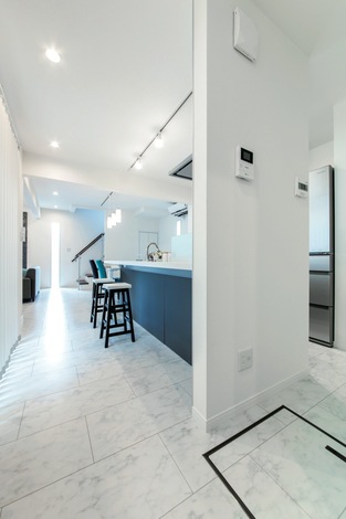 耐力壁を利用してアイランドキッチン風に。給湯のスイッチなどを来客から見えない壁面に取り付けた