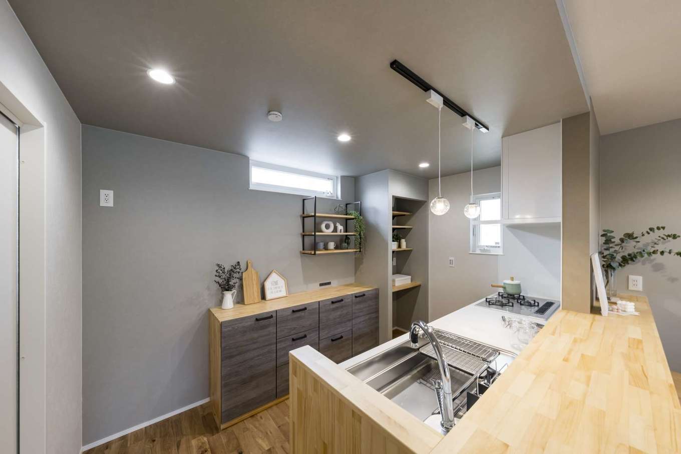Gate air house/阿部住宅【デザイン住宅、狭小住宅、省エネ】奥行きの長いキッチンカウンターと食器棚、見せる収納棚は造作。家族の様子を見守りながら料理することができて安心