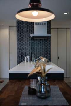 IHの横の壁には高級感のあるタイルを採用。照明も丁寧に選んだ