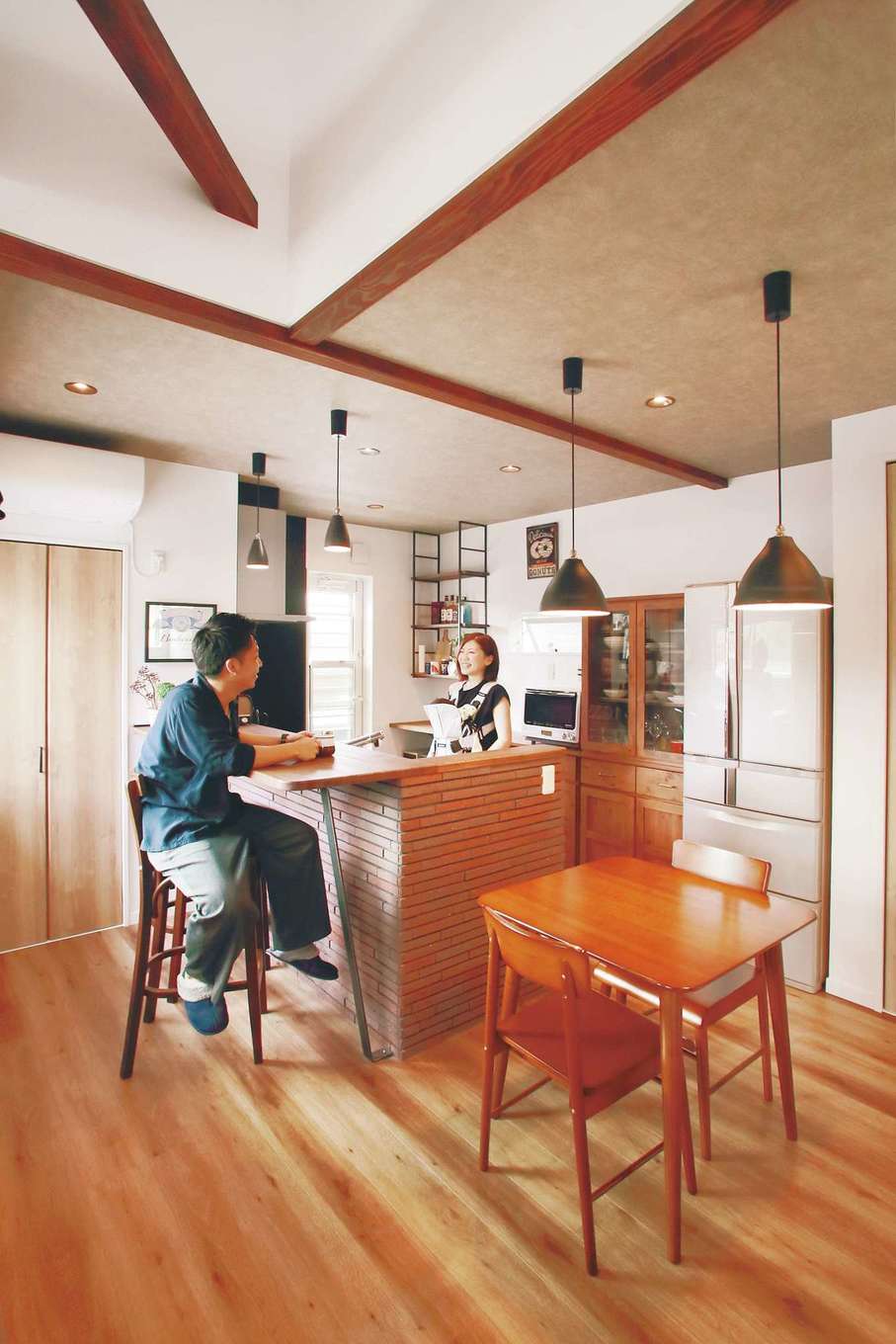 三和建設【趣味、間取り、インテリア】キッチンの壁のレンガ使いは、「プレゼンハウス®」で一目惚れしたもの。使い慣れたキッチン収納の色やテイストに合わせて、一部オープンシェルフを造作した。