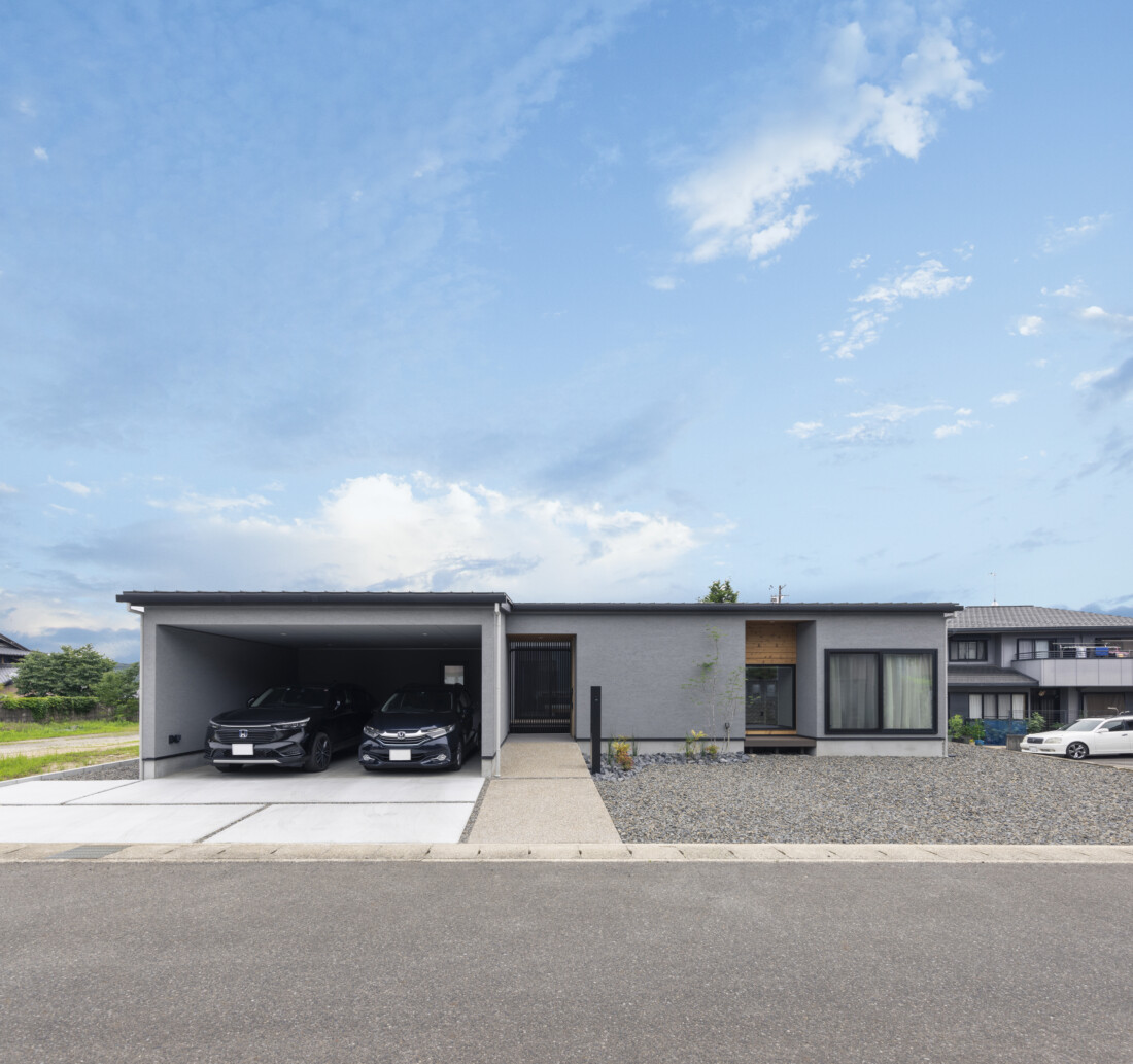 チェックハウス｜モダンな平屋の外観。シンプルで洗練されたデザインが、周囲の景観と調和している。車2台が駐車可能なゆったりとしたカーポートを備えている。