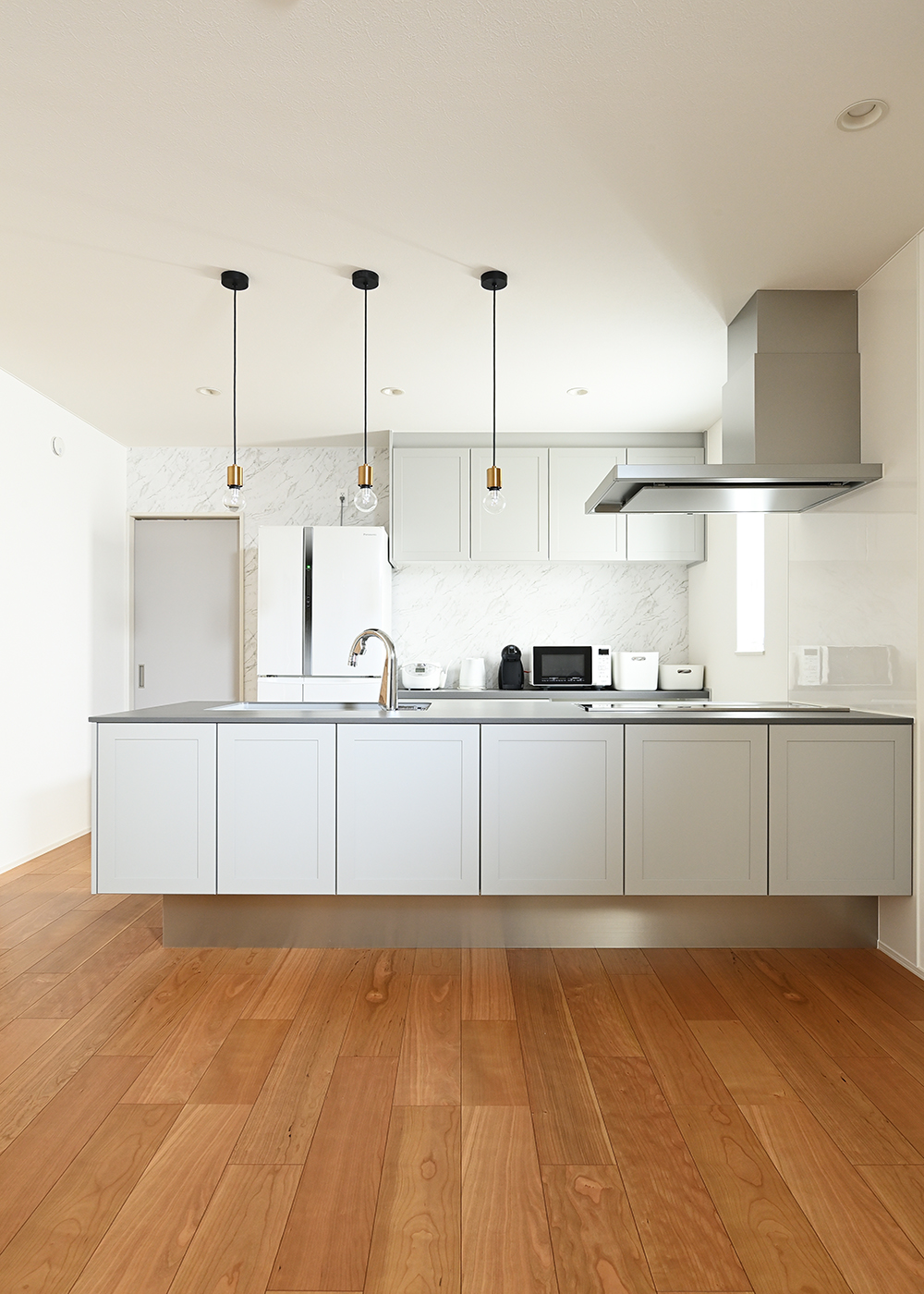 ナイスホーム【デザイン住宅、間取り】空間に溶け込むデザインと充実した収納が自慢のキッチン。奥の扉からファミリークローゼットへとつながっている