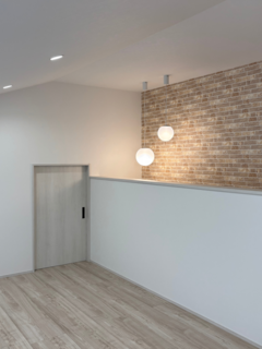 壁面にレンガ調のアクセントクロスを施した小屋裏収納。シンプルでありながら温かみのあるデザインが特徴です。