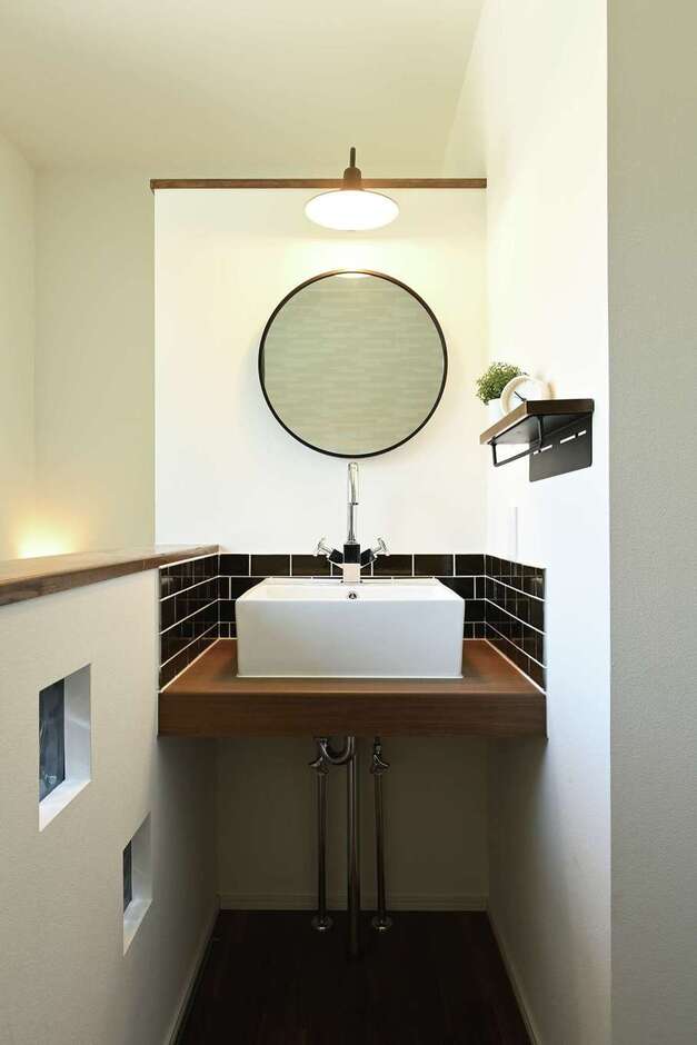 2階の手洗いコーナー。丸い鏡とタイルの組み合わせが素敵