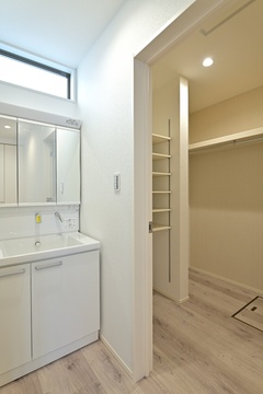 高窓から明かりが入る、明るく清潔感のある洗面スペース。真横にウォークインクローゼットを設け、朝の身支度やただいま動線も完璧。